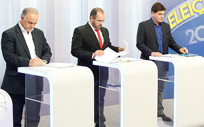 Três candidatos ainda olham anotações numa última preparação para o debate
